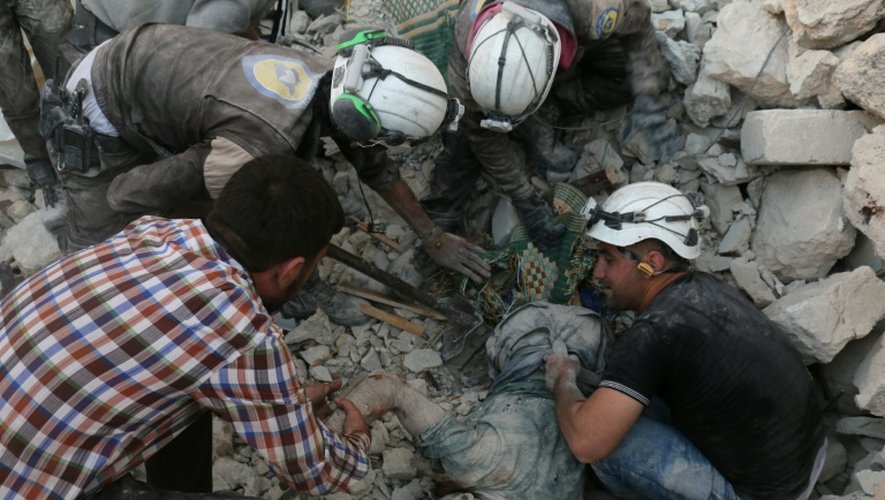 Le corps d'un homme extrait des décombres après un bombardement le 27 avril 2016 à Alep en Syrie