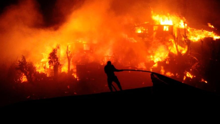 Des pompiers luttent contre les flammes le 12 avril 2014 à Valparaiso
