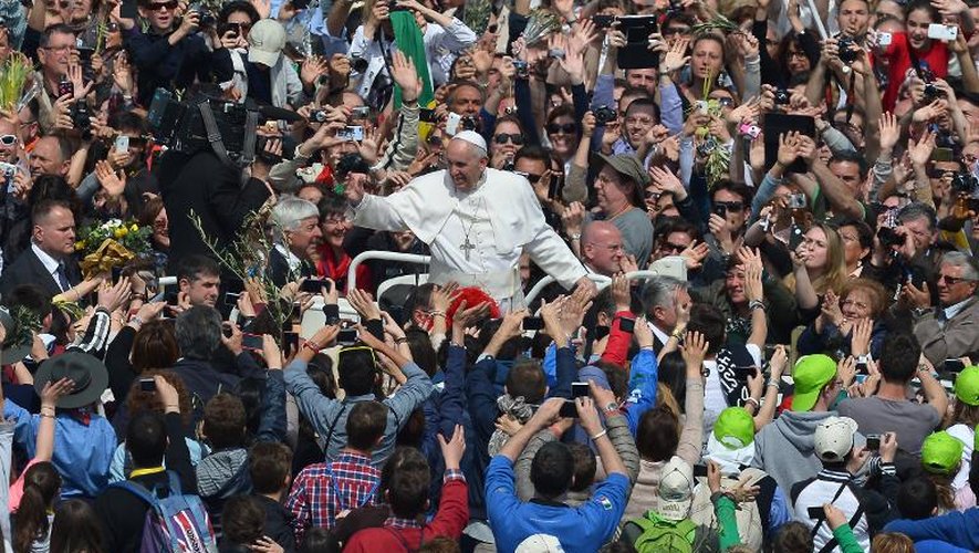 Le pape François salue la foule au Vatican après la messe des Rameaux, le 13 avril 2014