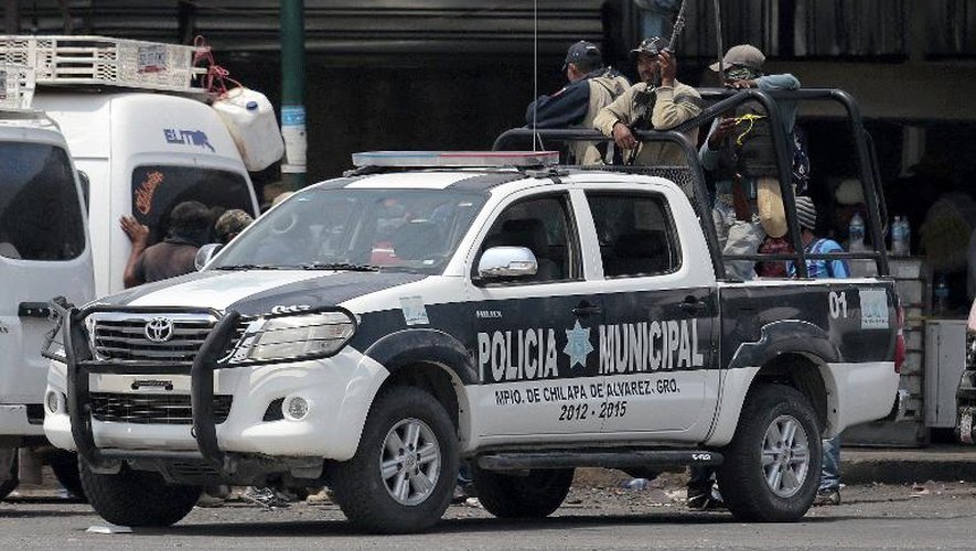 Des civils armés patrouillent à bord d'une voiture de la police municipale à Chilapa, dans le sud du Mexique, le 10 mai 2015