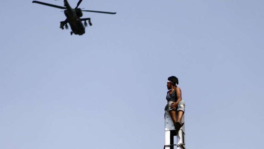 Un hélicoptère de l'armée survole le Caire sous les yeux d'un opposant au président Morsi, le 2 juillet 2013