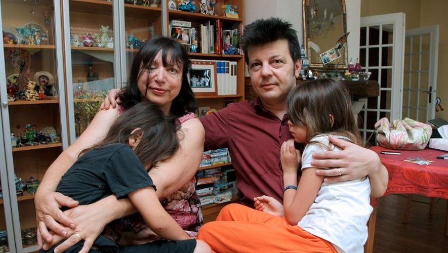 Sylvie et Dominique Mennesson, parents de jumelles nées en 2000 d'une mère porteuse californienne, posent avec leurs filles, le 2 juillet 2009 dans leur maison de Maison-Alfort
