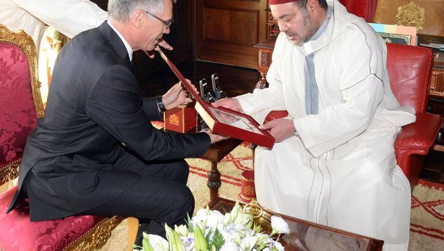 Le roi du Maroc Mohamed VI reçoit un cadeau des mains de Carlos Tavares, patron de PSA Peugeot Citroën, le 19 juin 2015 au palais royal de Rabat