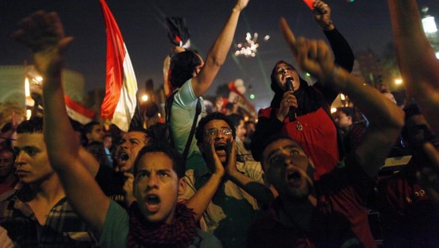 Des manifestants regardent sur un écran le discours du président Morsi dans une rue près du palais présidentiel, au Caire le 3 juillet 2013