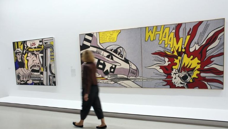 Une personne passe devant les oeuvres "Torpedo...Los!"(g) et "Whaam" de l'artiste américain Roy Lichtenstein exposées au Centre Georges Pompidou, le 30 juin 2013 à Paris