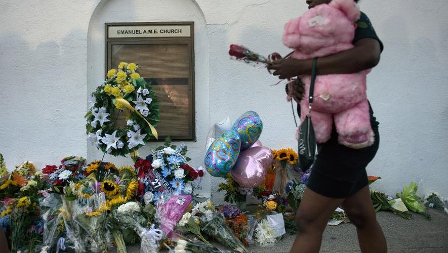 Une femme apporte des fleurs devant l'Emanuel African Methodist Episcopal Church, le 18 juin 2015, au lendemain de la fusillade qui a fait neuf morts
