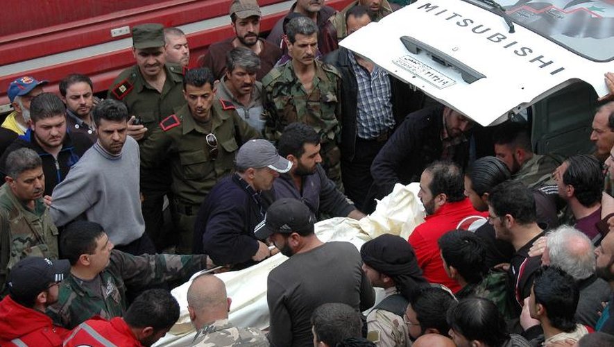 Du personnel médical et de secours évacue les victimes de l'explosion d'une voiture piégéerue  al-Ushaq dans le voisinage d'Ekremah, à Homs en Syrie le 14 avril 2014