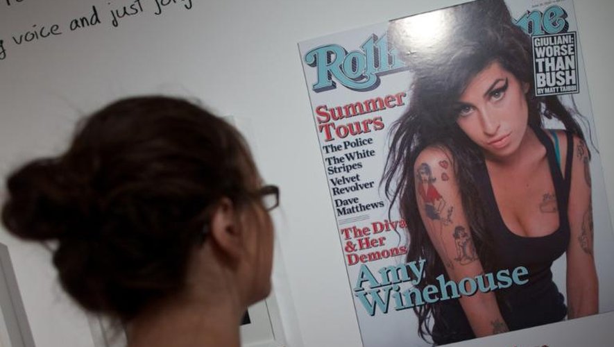 Une femme regarde un cliché d'Amy Winehouse en couverture du magazine Rolling Stone, le 2 juillet 2013 au Musée juif de Londres