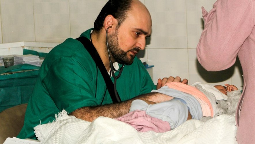 Photographie transmise le 29 avril 2016 par l'Association ds médecins indépendants (IDA), montrant le docteur Mohammad Wassim Maaz oscultant un enfant dans un hôpital syrien d'Alep le 20 février 2016.