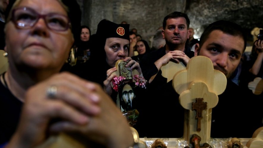 Des chrétiens orthodoxes serbes portent des croix de bois dans l'église Saint-Sépulcre à Jérusalem, le 29 avril 2016