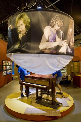 Des techniciens installent un piano sous une affiche de Polnareff deux jours avant l'ouverture le 20 juin d'une exposition sur l'artiste aux lunettes blanches, à Montluçon