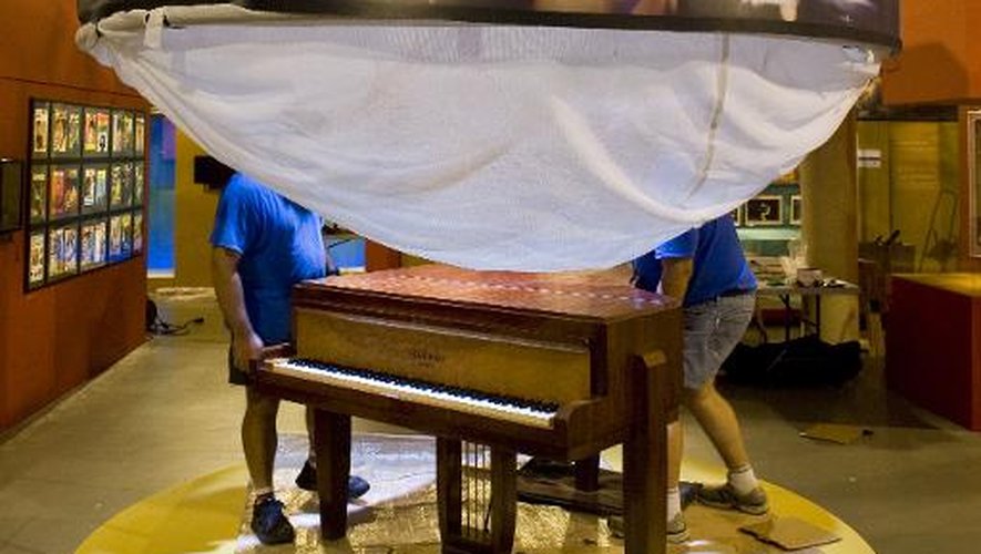 Des techniciens installent un piano sous une affiche de Polnareff deux jours avant l'ouverture le 20 juin d'une exposition sur l'artiste aux lunettes blanches, à Montluçon
