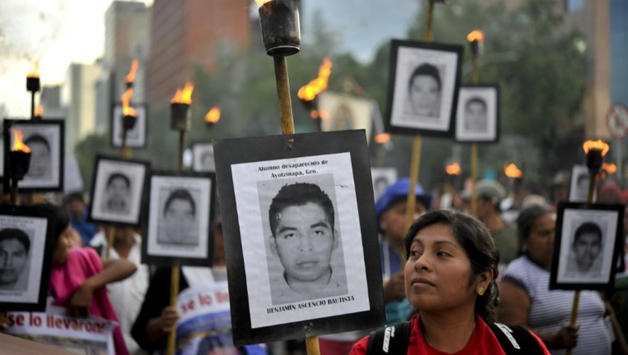 Les portraits d'étudiants disparus brandis par leurs proches lors d'une marche le 26 avril 2016 à Mexico