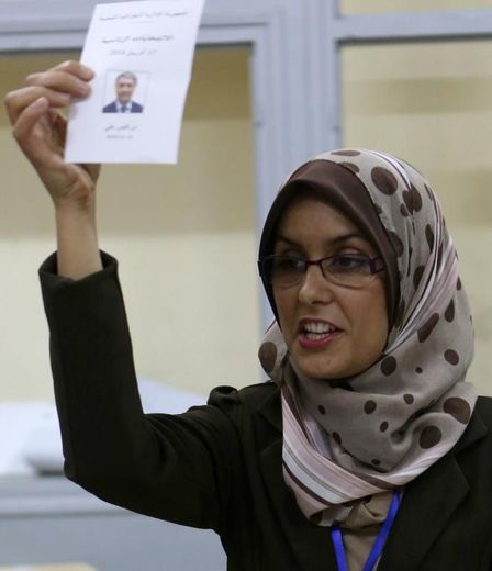 Une femme membre de la commission électorale montre un bulletin de vote d'Ali Benflis lors du dépouillement du scrutin le 17 avril 2014 à Alger