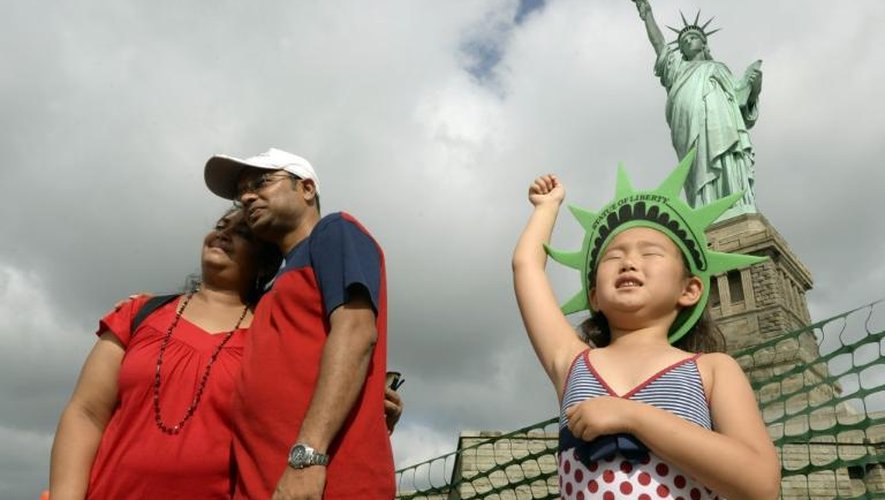 Des touristes devant la statue de la Liberté à Liberty Island, à New York, le 4 juillet 2013