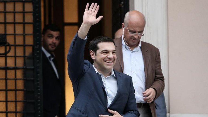 Alexis Tsipras salue des personnes qui l'attendaient à la sortie du siège du gouvernement le 21 juin 2015 à Athènes