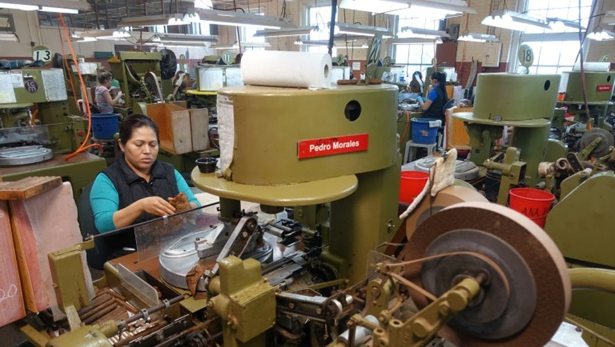 Des employés de la fabrique de cigares de J.C. Newman, travaillent sur des machines très anciennes, à Tampa en Floride le 21 avril 2016