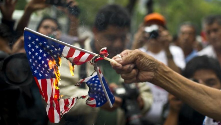 Une femme brûle un drapeau américain lors d'une manifestation de soutien au président bolivien Evo Morales face à l'ambassade des Etats-Unis à Mexico, le 4 juillet