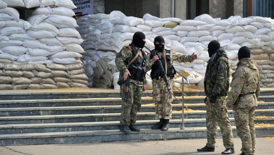 Des hommes armés gardent le bâtiment de l'administration régionale occupé par les insurgés séparatistes à Slavyansk le 18 avril 2014