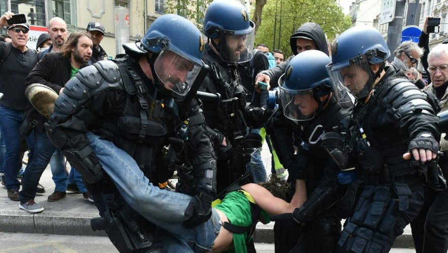 Des policiers interpellent un manifestant en marge de la manifestation contre la loi travail le 28 avril 2016 à Lyon