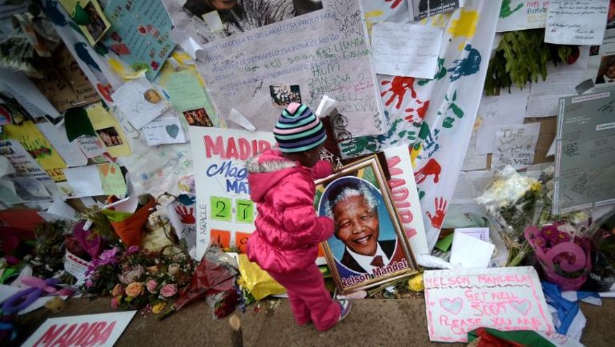 Une petite fille devant la clinique où l'ex-président sud-africain Nelson Mandela est hospitalisé, à Pretoria, le 6 juillet 2013