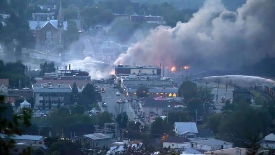 De la fumée s'élève au dessus du centre ville de Lac-Mégantic ravagé le 7 juillet 2013 par l'explosion d'un convoi de wagons-citernes