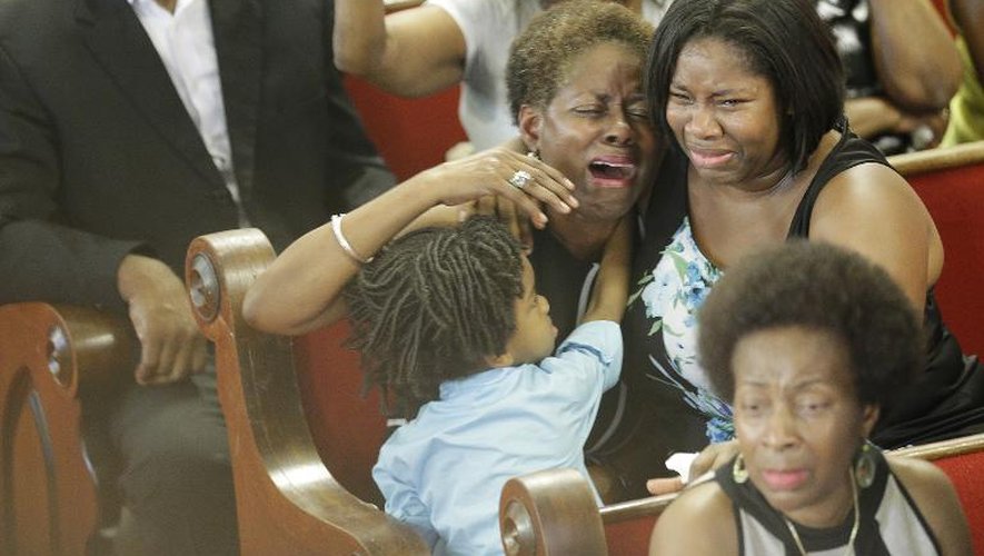Des prières et des larmes lors de la célébration le 21 juin 2015 à l'église Emanuel de Charleston, en Caroline du sud, du premier office après la tuerie à caractère raciste de neuf paroissiens noirs