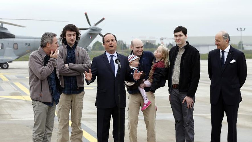Le président François Hollande est entouré des quatre ex-otages et de Laurent Fabius (droite) à l'aéroport de Villacoublay le 20 avril 2014