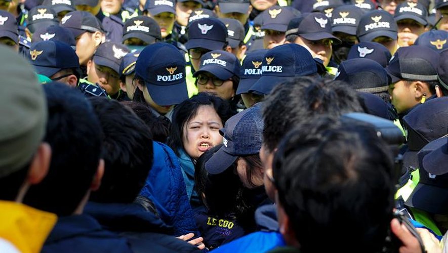 Des proches des passagers disparus du ferry naufragé affrontent la police alors qu'ils marchent vers le palais présidentiel pour protester contre les opérations de secours le 20 avril 2014 à Jindo