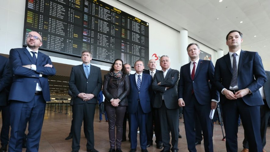 Le Premier ministre Charles Michel (g), et le ministre de l'Intérieur belge, Jan Jambon (2e g), à l'aéroport de Zaventem, près de Bruxelles, lors de la cérémonie de réouverture du hall des départs, fermé depuis les attentats du 22 mars dernier
