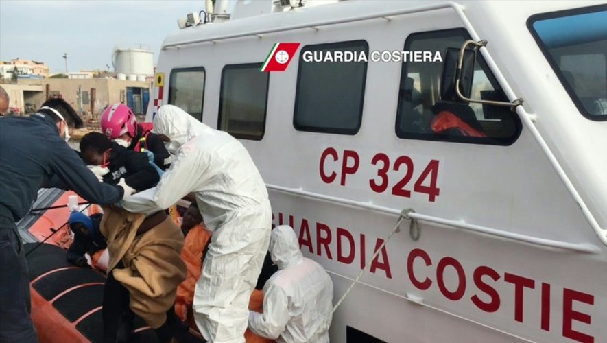 Photographie publiée le 30 avril 2016 par les gardes-côtes italiens montrant des migrants débarquant au port de Lampedusa après une opération de sauvetage, au large de la Libye