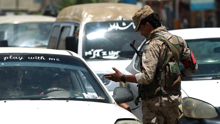 Un soldat yéménite discute avec un automobiliste à Sanaa le 20 avril 2014 alors que les mesures de sécurité sont renforcées suite à des attaques de drones