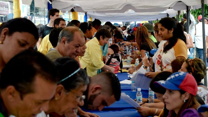 Des Vénézuéliens signent un document pour réclamer un referendum afin de démettre le président Maduro, dans les rues de Caracas, le 27 avril 2016