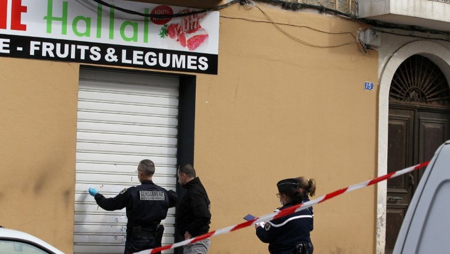 Des policiers constatent des impactes de balles sur la devanture d'un magasin d'alimentation Hallal à Propriano en Corse, le 3 février 2016