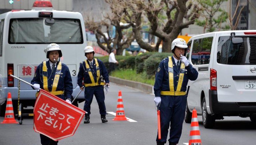 Des policiers inspectent les voitures à proximité de l'ambassade américaine à Tokyo le 22 avril 2014