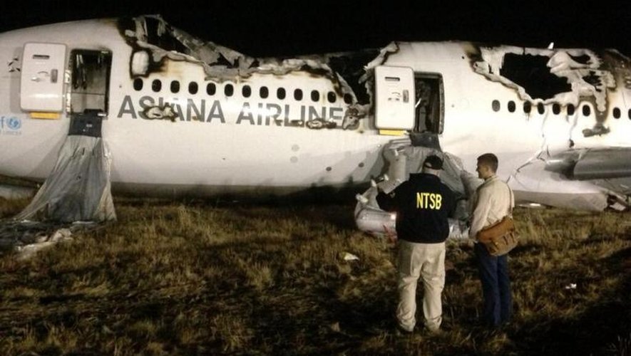 Des experts de la NTBS enquêtent sur le lieu où un Boeing 777 a pris feu à l'aéroport de San Francisco, le 7 juillet 2013