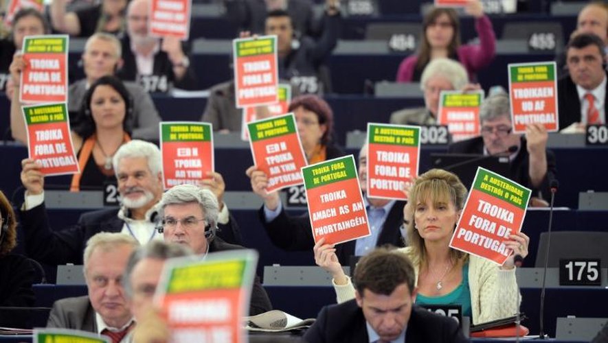 Des membres du Parlement européen brandissent des affiches pendant un discours du présidnet portugais, à Strasbourg, le 12 juin 2013