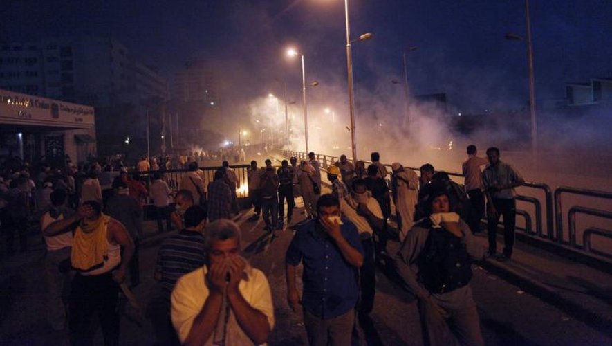 Des partisans des Frères musulmans se dispersent lors de heurts avec la police devant le siège de la Garde républicaine, le 8 juillet 2013 au Caire