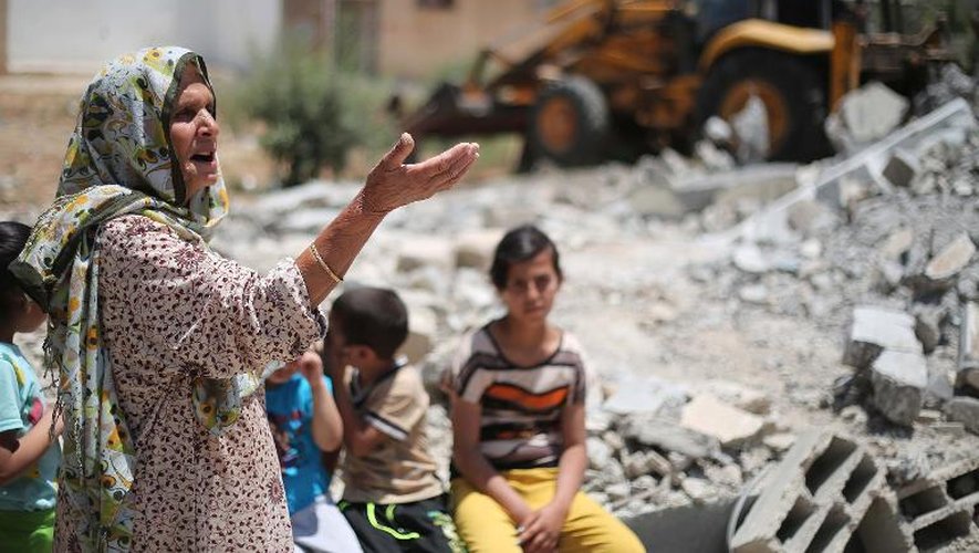 Des Palestiniens font des travaux pour enlever les ruines d'immeubles détruits lors de la guerre à Gaza en 2014, dans le village de Khuzaa, dans la Bande de Gaza, le 1er juin 2015