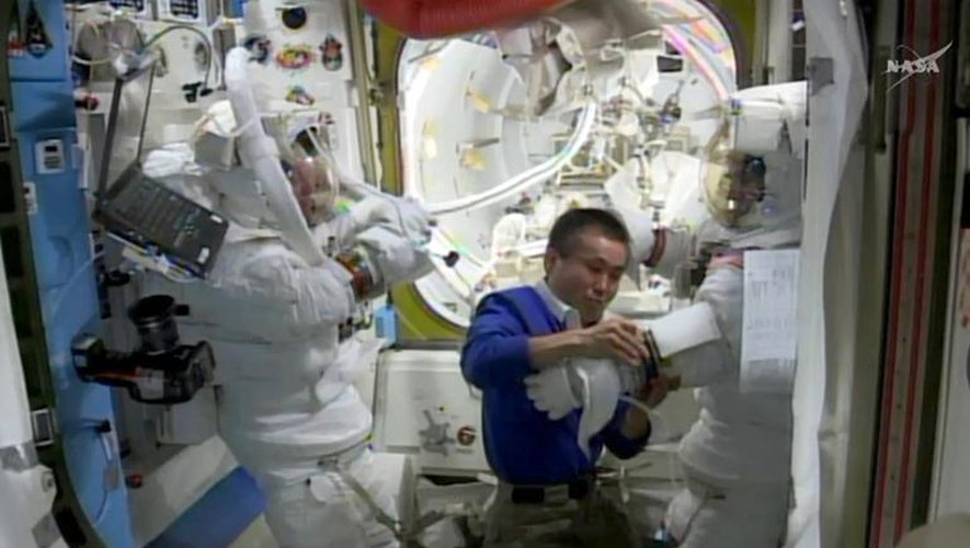 Image de la Nasa TV le 23 avril 2014 montrant l'astronaute japonais Koichi Wakata(c) aidant les Américains Steve Swanson(g) and Rick Mastracchio qui ont effectué avec succès une réparation à l'extérieur de la Station spatiale internation