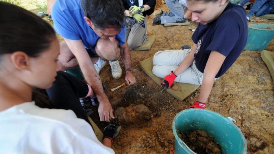 Sous la supervision du paléontologue Yves Laurent (c), des jeunes volontaires sont à la recherche de fossiles sur le site du Montréal-du-Gers,près de Toulouse, le 8 juillet 2013
