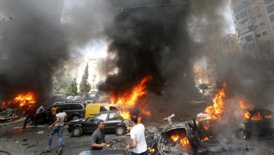 Des habitants s'activent pour éteindre l'incendie déclenché par l'explosion d'une voiture piégée, le 9 juillet 2013 à Beyrouth