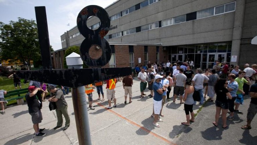 Les rescapés de l'explosion d'un train contenant du pétrole à Lac-Mégantic, au Québec, se retrouvent devant le lycée de la ville le 7 juillet 2013