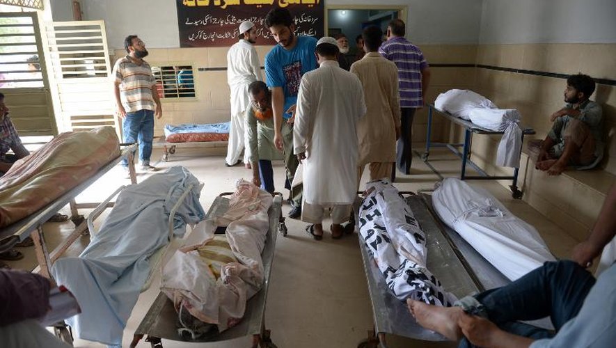 Des familles au milieu des dépouilles de personnes ayant succcombé à la canicule, le 23 juin 2015 à la morgue Edhi de Karachi