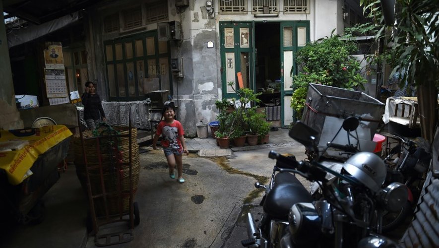 Une fillette joue le 12 avril 2016 dans une allée du quartier chinois de Bangkok, qui abrite des maisons anciennes, qui relèvent du patrimoine historique