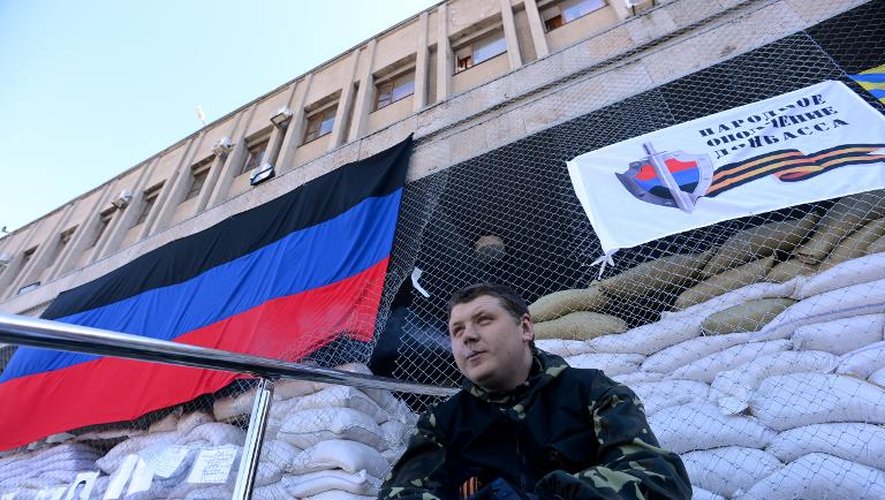 Des hommes armés gardent un bâtiment de l'administration assiégé par les pro-Russes à Slaviansk le 25 avril 2014