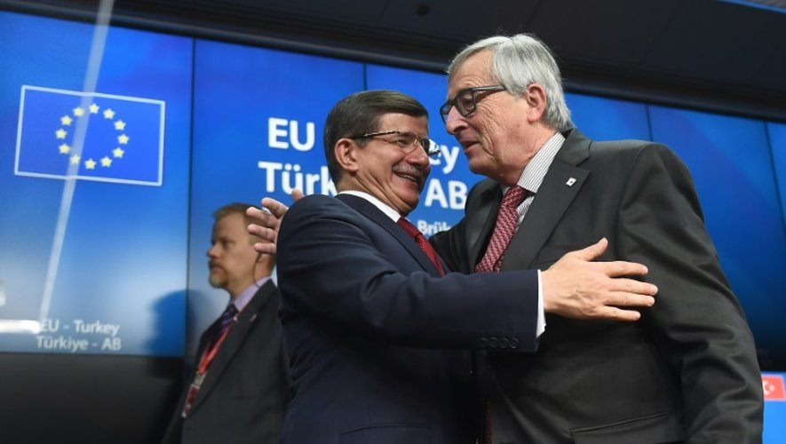 Le Premier ministre turc Ahmet Davutoglu (g), salue le président de la Commission européenne Jean-Claude Juncker, à Bruxelles, le 29 novembre 2015