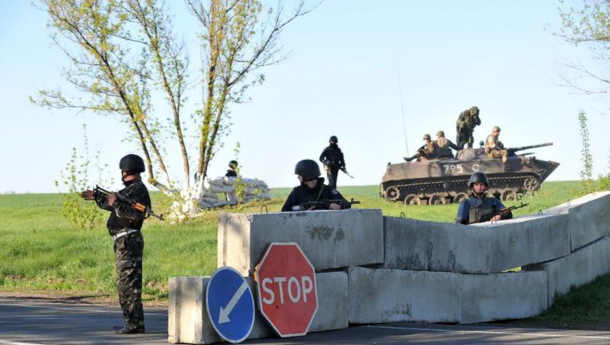 Policiers et soldats ukrainiens montent la garde à un poste de contrôle érigé le 25 avril 2014 près de Slaviansk