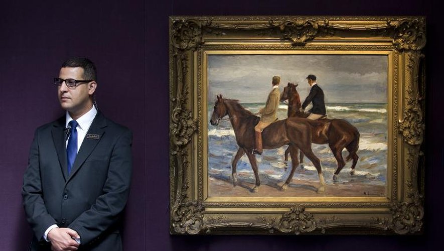 Un vigile monte la garde devant le tableau du peintre allemand Max Liebermann "Deux cavaliers à la plage" (1901), lors d'une présentation à la presse à Londres le 19 juin 2015, avant sa vente aux enchères