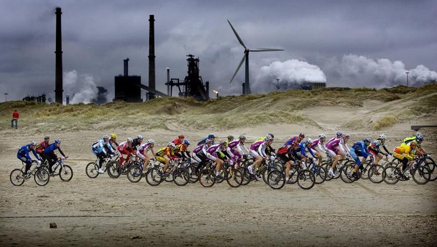 Des cyclistes prenant part le 13 janvier 2006 à une compétition passent devant une usine près du village néerlandais de Wijk aan Zee, sur la mer du Nord